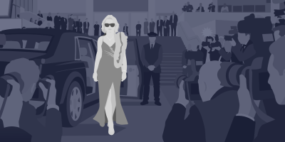 Eine blonde Frau im eleganten Abendkleid mit Sonnenbrille geht neben einer dunklen Limousine über einen roten Teppich, umringt von Pressefotografen.