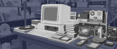 Ein alter Röhrencomputer steht auf einem Tisch, umgeben von Vintage-Elektronik wie Wählscheibentelefon, Tonbandgerät, alten Handys und Plattenspieler in einem Trödelladen.