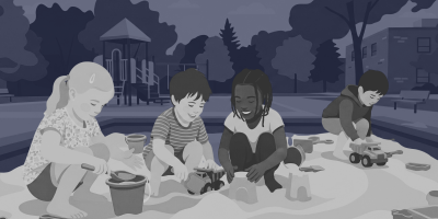 Vier Kinder hocken in einem Sandkasten auf einem Spielplatz und bauen mit Eimern, Schaufeln und Spielzeuglastern Sandburgen.